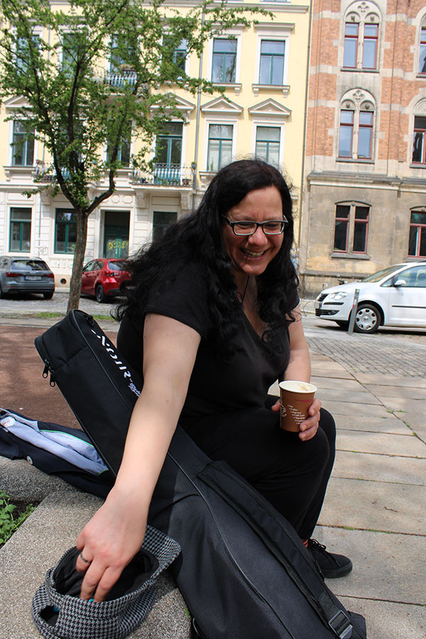Musikerin Anja Odefey in Dresdner Neustadt mit Mütze und Gitarre